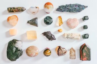 A serene setting featuring various colorful crystals arranged on a soft surface, with a blurred background of a peaceful meditation space.