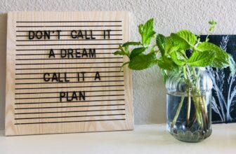 A colorful vision board filled with inspiring images, quotes, and goals, set against a bright workspace.