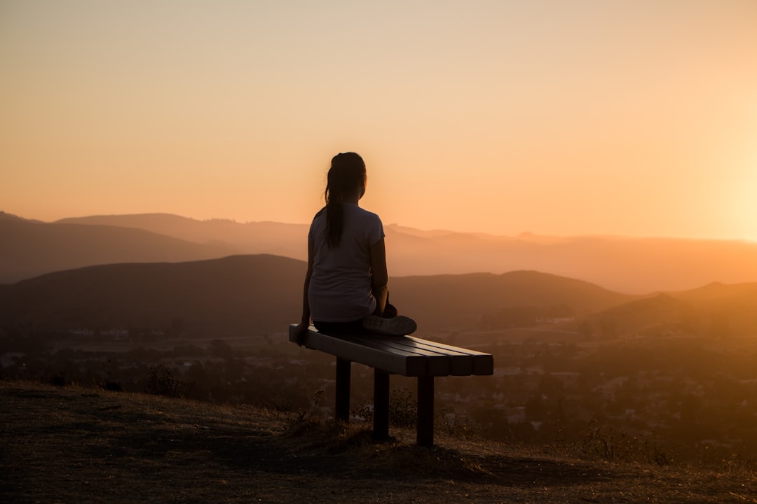 A serene setting for meditation, featuring a person sitting cross-legged on a mat in a peaceful environment, surrounded by nature or soft lighting.