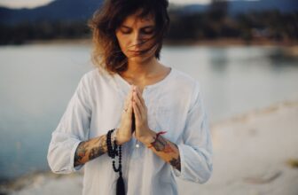 A serene landscape with a person meditating in nature, surrounded by trees and soft sunlight, symbolizing peace and grounding during a spiritual journey.