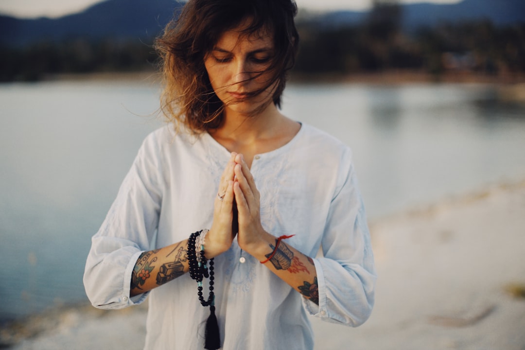 A serene landscape with a person meditating in nature, surrounded by trees and soft sunlight, symbolizing peace and grounding during a spiritual journey.